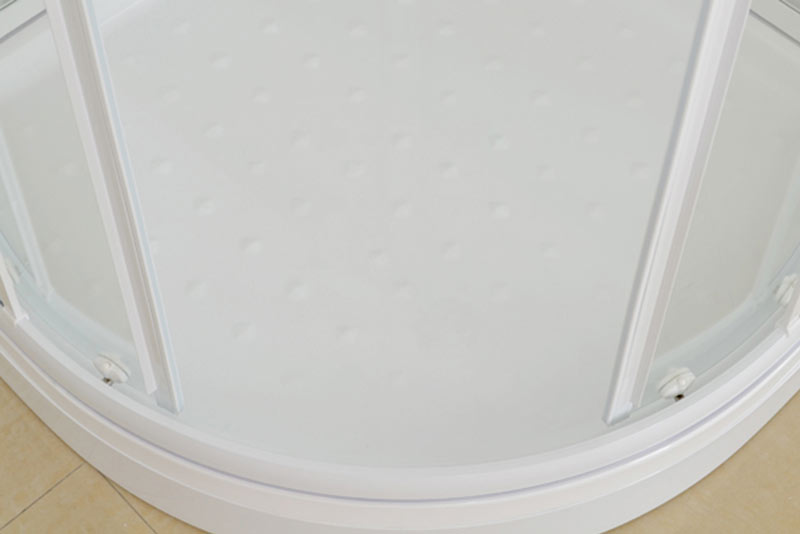 White molded shower base with raised dot non-slip surface inside a white framed corner glass enclosure