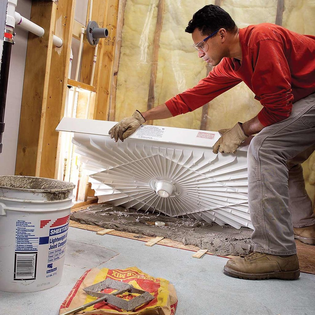 a man installing a shower tray