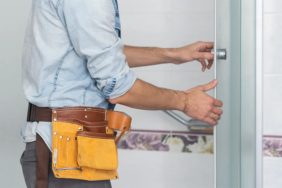 un uomo installa la porta della doccia