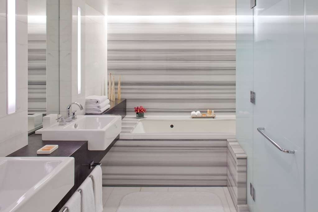 Commercial building interior with frameless glass shower door and marble bathroom finishes