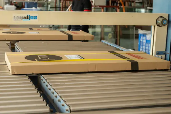 Automated packaging line with flat-packed boxes moving on roller conveyors in the KJbath shower wall panel factory