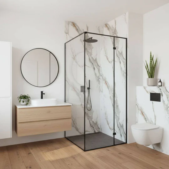 Slim black framed glass shower screen with marble-look wall panels, floating wood vanity and wall-hung toilet in a bathroom