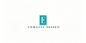 Embassy Suites hotel logo with teal square white E emblem and black uppercase brand name below